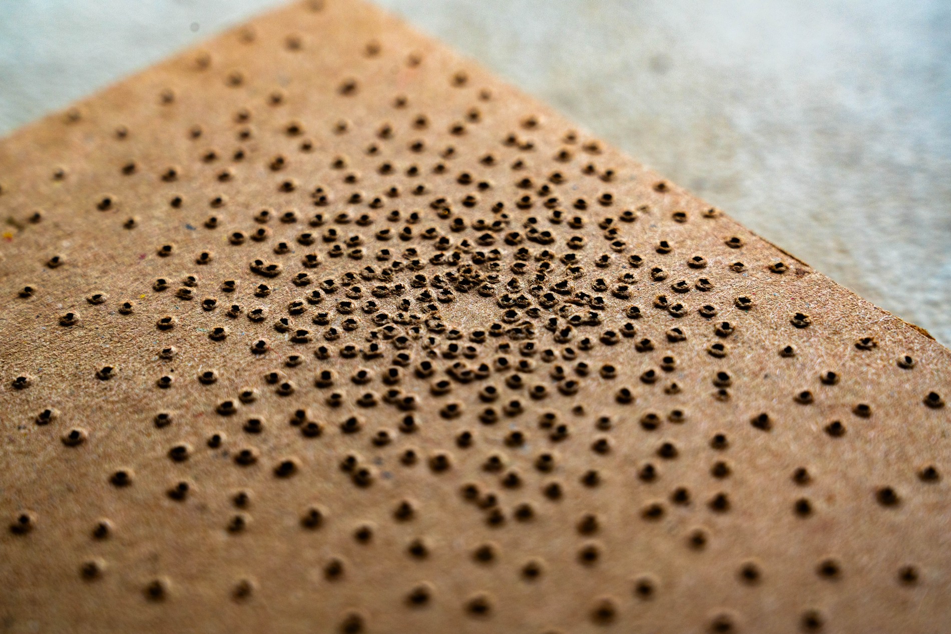 Point of Light packaging, 90% cocoa perforation pattern, dense cluster of holes at close range