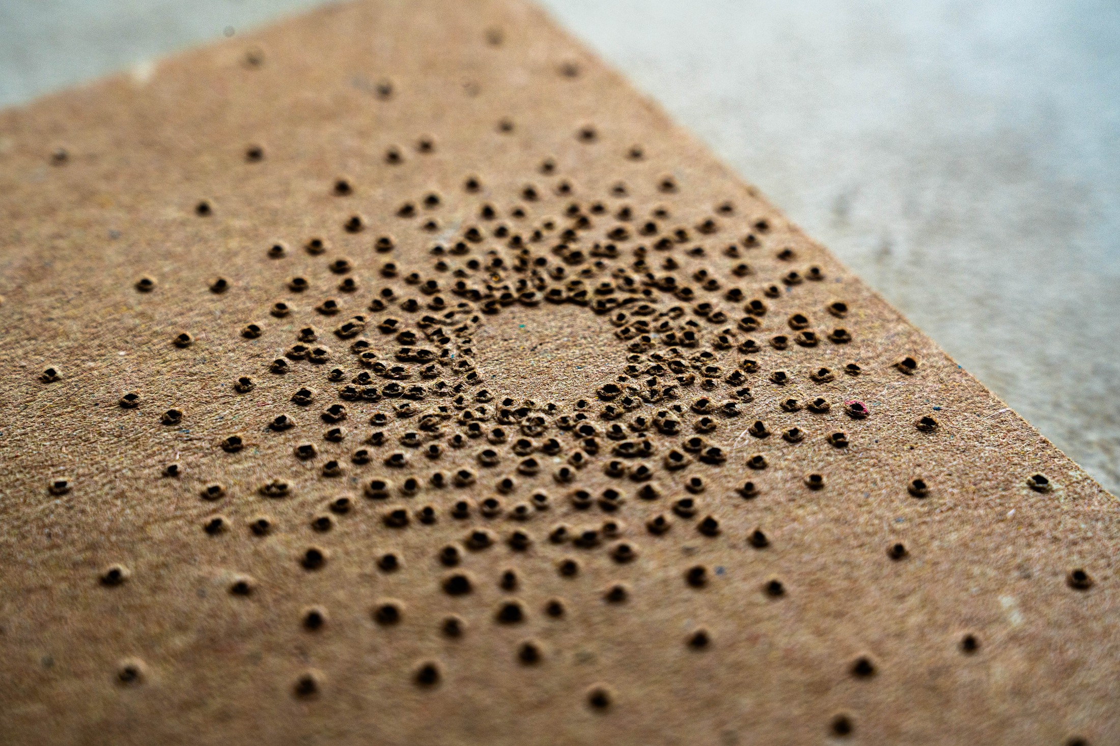 Point of Light packaging, macro detail of the 80% cocoa perforation pattern punched through the cardboard