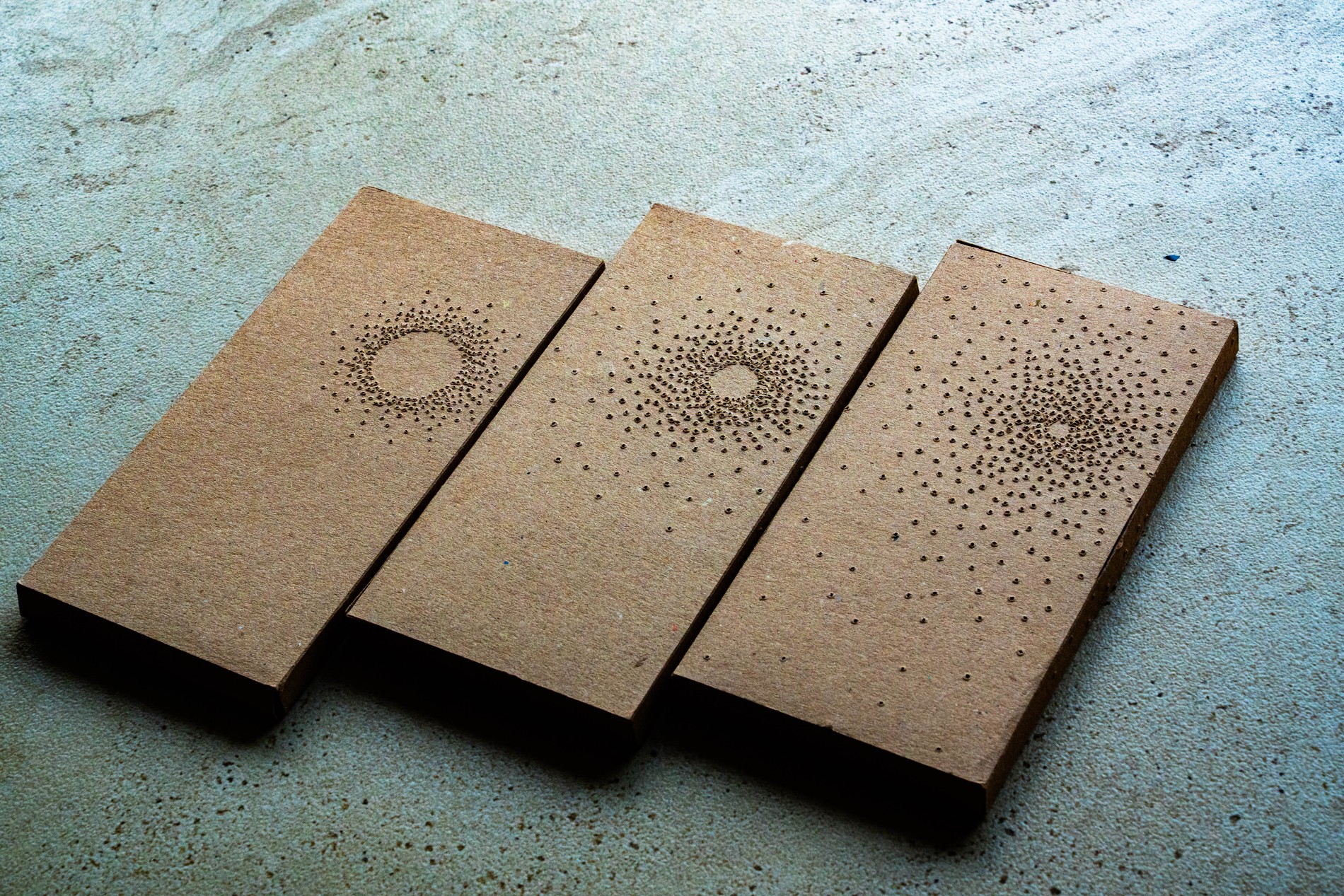 Point of Light packaging, three chocolate boxes side by side showing the full range of perforation patterns