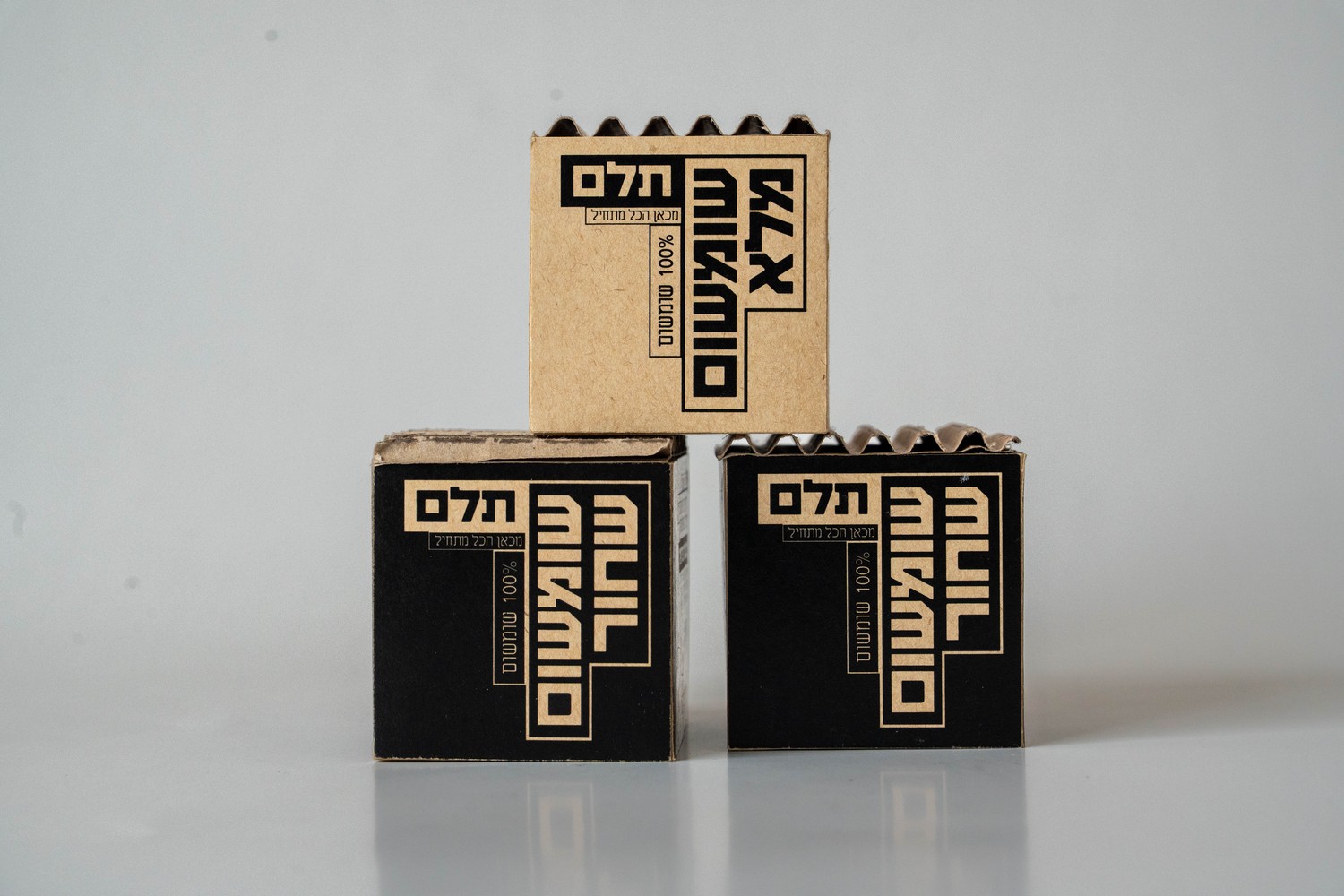 Telem sesame boxes stacked in a pyramid, kraft and black variants